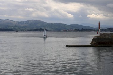 Bazı beyaz bulutlar ve yelkenli tekneler ile bir gün Santander bay.
