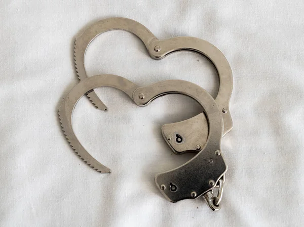Handcuffs with white heart-shaped background. — Stock Photo, Image