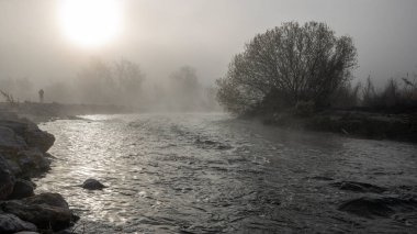 Güneş doğarken Serpis nehri çok sakin ve sisli solda bir adamla, Alicante, İspanya.