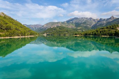 Güneşli bir günde sudaki yansımalarla Guadalest bataklığı.
