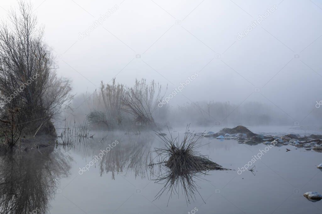 Serpis river at sunrise very calm and foggy, Alicante, Spain.