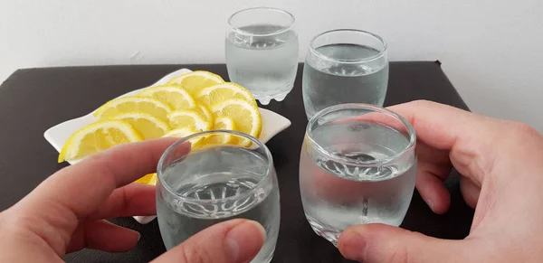 Deux Mains Tiennent Des Verres Avec Vodka Sur Table Marron — Photo