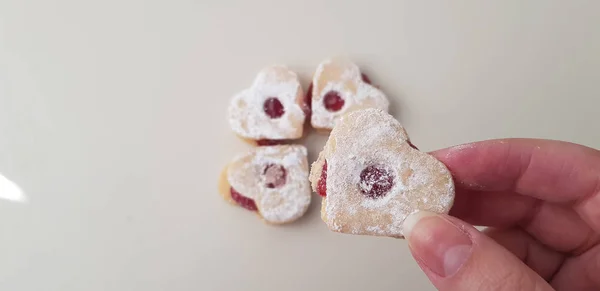 Une Fille Tient Dans Ses Doigts Biscuit Forme Coeur Avec — Photo