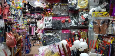 Rishon lezion, İsrail - 5 Mart 2019: beyaz numara şeytan stics önce Yahudi purim maskeli bir dükkanda Satılık maruz çocuklar için fantezi elbise ve diğer plastik malzeme maskeleri