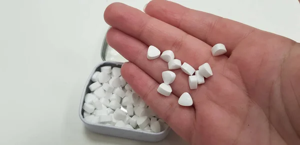 Kilka Małych Cukierków Biały Ludzką Ręką Palm Nad Otwartym Metalowe — Zdjęcie stockowe
