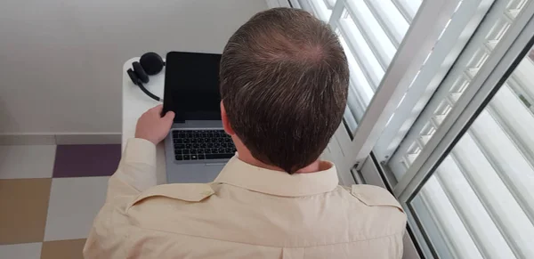 Rückansicht Eines Mannes Mit Dienstkragenhemd Der Fenster Über Offenem Laptop — Stockfoto