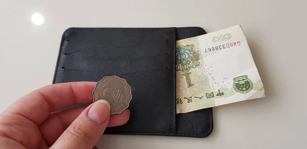 Weibliche Hand Hält Zwei Hongkong Dollar Münzen Über Schwarzer Brieftasche — Stockfoto