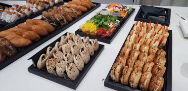 Ofisteki iş zirvesinde siyah tabaklar üzerinde kişisel sebze ve sandviç servisleri.