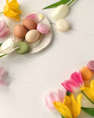 Renkli macarons ve bir beyaz ahşap tablo Easter eggs