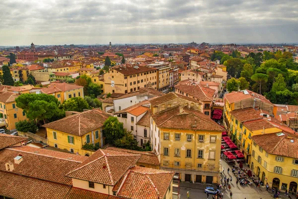 Pisa, Toskana/İtalya - 25.10.2018: Ünlü Eğik Kule'den Pisa'nın panoramik manzarası. İtalyan yaşam evleri, kafeler, kiliseler, sokaklar. Ufukta dağlar var. Bulutlu gökyüzü.