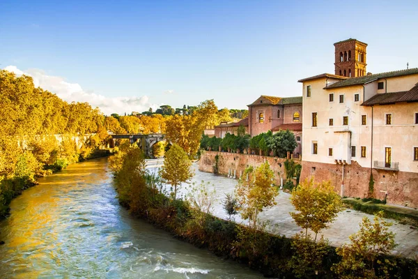 Roma, Lazio/İtalya - 30.10.2018: Tiberina adası, Caetani kalesi, ortaçağ binaları. Altın sonbahar. Tiber Nehri. Fabricio köprüsünden görünüm