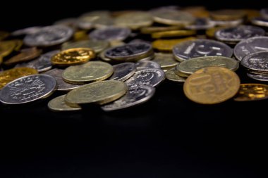 Sikkeler kavram duvar ve güçlü para siyah arka plan üzerinde yığını.