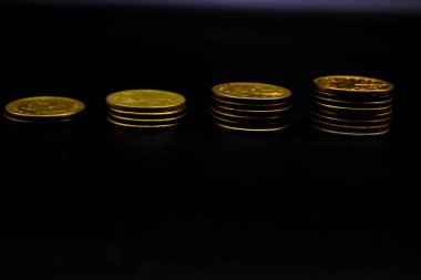 Sikkeler kavram duvar ve güçlü para siyah arka plan üzerinde yığını.