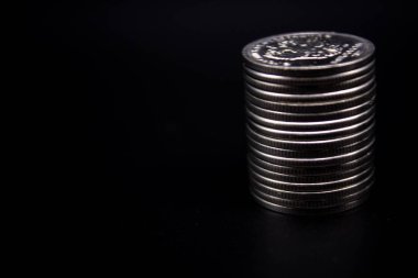 Sikkeler kavram duvar ve güçlü para siyah arka plan üzerinde yığını.