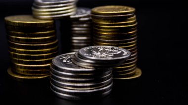 Sikkeler kavram duvar ve güçlü para siyah arka plan üzerinde yığını.