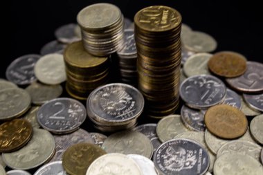 Sikkeler kavram duvar ve güçlü para siyah arka plan üzerinde yığını.