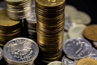 Sikkeler kavram duvar ve güçlü para siyah arka plan üzerinde yığını.