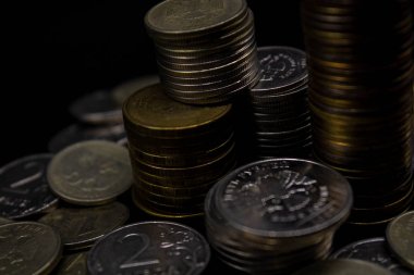Sikkeler kavram duvar ve güçlü para siyah arka plan üzerinde yığını.