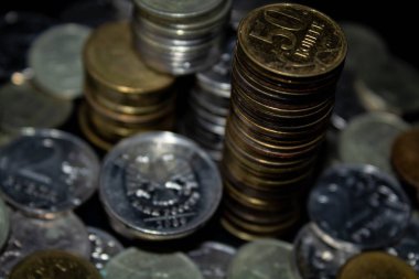 Sikkeler kavram duvar ve güçlü para siyah arka plan üzerinde yığını.