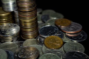 Sikkeler kavram duvar ve güçlü para siyah arka plan üzerinde yığını.