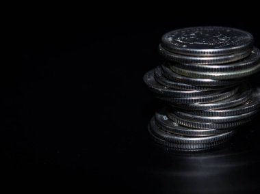 Sikkeler kavram duvar ve güçlü para siyah arka plan üzerinde yığını.