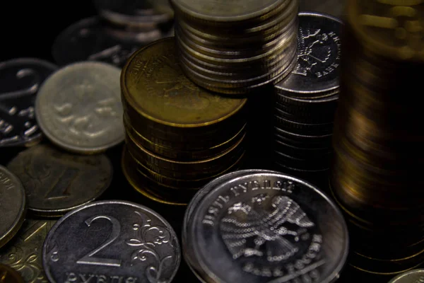 Sikkeler kavram duvar ve güçlü para siyah arka plan üzerinde yığını.