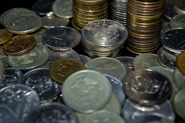 Sikkeler kavram duvar ve güçlü para siyah arka plan üzerinde yığını.