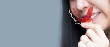 Güzel closeup gülümseyen kadın diş diş teli ile. Kavram Ortodonti diş Asyalı Çinli Tay kadın kadın makyaj yüz. Kadın pembe dudakları ve sağlıklı diş beyaz harika mükemmel diş ile.