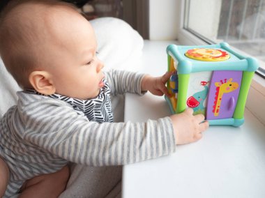 Şirin 6 ay eski yarış Asya beyaz çocuk mutlu gülümseyerek ve kameraya, gülen sağlıklı çocuk bebek çocuk arıyorsunuz karışık kapatın. Tarama, beyin gelişimi için oyuncaklar harita spor salonu ile oynamak başlayan bebek