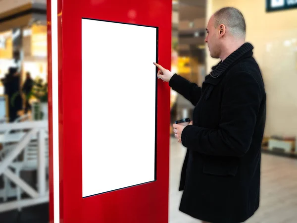 Un hombre con los medios digitales en blanco y negro pantalla panel moderno, letrero para el diseño de anuncios en un centro comercial, galería. Burla, maqueta, maqueta con fondo borroso, quiosco digital . — Foto de Stock