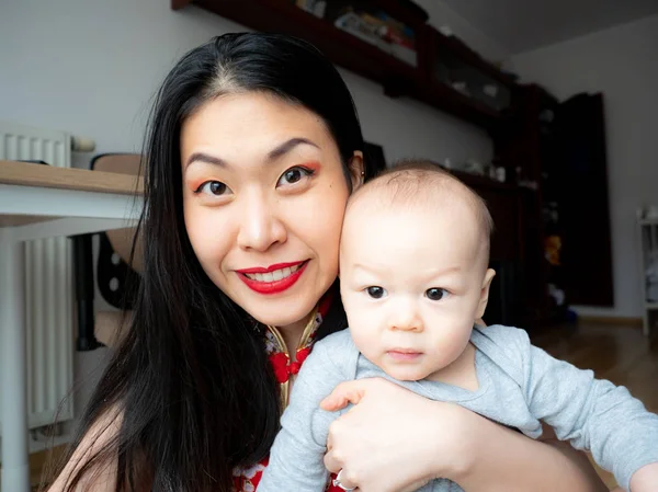Mutlu anne ve sevimli bebek oğlu kameraya bakarak el sallayarak, dostu anne ya da bebek bakıcısı ve Selam Merhaba webcam ya da veda online yapma gülümseyen çocuk çocuk portre vlog ara
