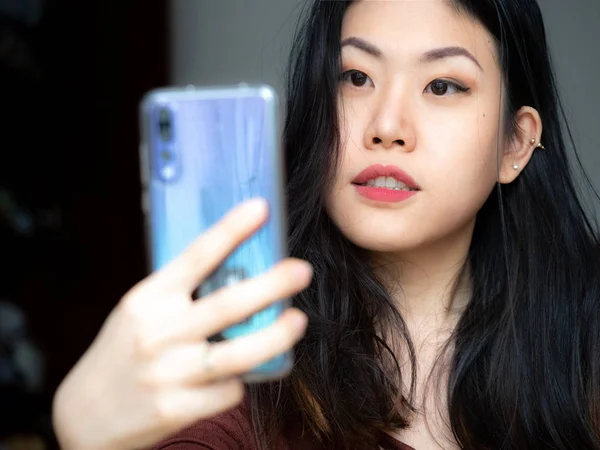 Image of excited Asian Chinese Thai Filipino beautiful happy young woman make selfie by camera at home, Adorable happy glad to see friend, family making video call by Internet.