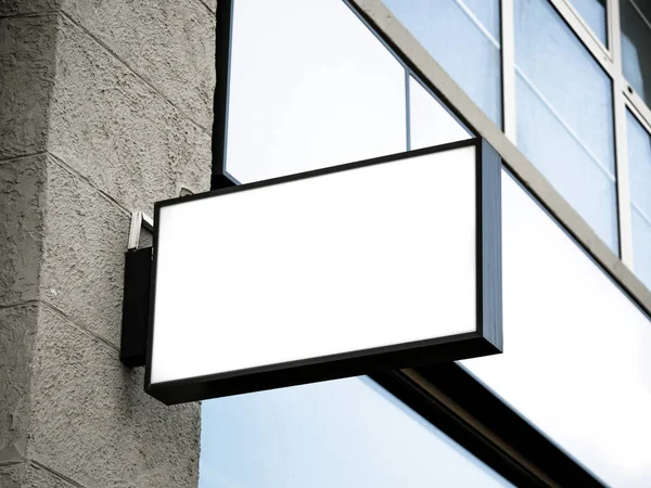 Black frame signboard side view of empty white mock-up modern with city brick wall background exterior display. Signboard side view of empty white mock up, squared, box, signage.