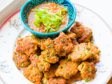 Derin kızarmış balık mantı, salatalık dilimleri olan turşu ile Tay balık köftesi derin kızarmış fesleğen yaprakları ile süslenmiş hizmet vermektedir