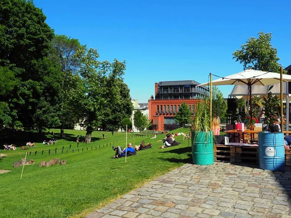 Outdoor cafe in the park, Europe. People with green trees and old building background. — Stock Photo, Image