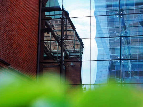 Office building, block, red brick, skyscraper made of metal and glass, sky reflections on windows, finance center, bank, business apartments, spy, observation, monitoring, blurry tree on the front — Stock Photo, Image