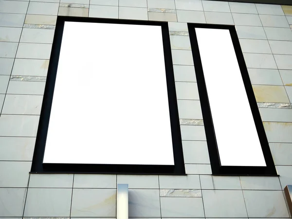 Big signboard billboard view of empty white mock up, mock-up signage in a black frame on a shopping centre, gallery wall, display panel exterior