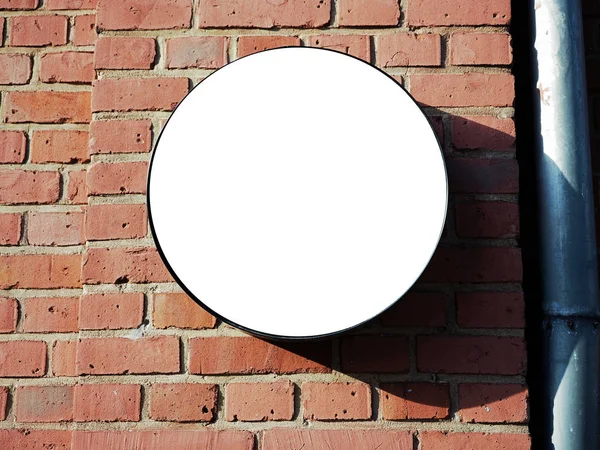 Jelzőtábla oldalnézetből üres fehér árnyéka mintája fel egy fekete keretet, a régi vörös téglából épült város fal háttér bemutatás külső jelzések. Nagyon modern formája Stock Kép