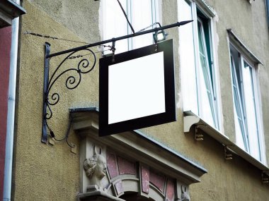 Eski şehir duvar arka plan ekran dış ile siyah bir çerçeve içinde boş beyaz Mock yukarı tabelas Signboard yan görünümü. Sanatsal metal Demircilik dekorasyonu ile modern tarzı