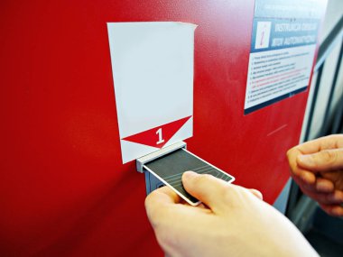 Alışveriş merkezinde Park ödemek için makineye bilet kartı ekleyerek bir adam. Tasarım için boş reklam modeli.