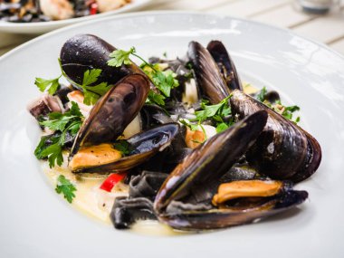 Restoranda beyaz tabak pişmiş ve pişmiş midye.