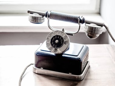 Eski ahşap masada döner disk ile Vintage Retro tarzı siyah metal Gümüş telefon.