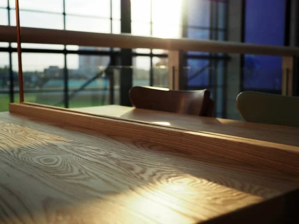 Поверхность светлого деревянного пустого стола в шикарном, элегантном кафе с факелами заката, кафе — стоковое фото