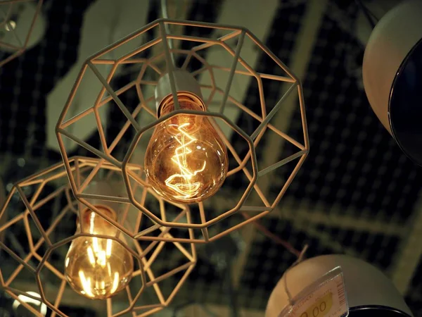 Uma lâmpada com uma sombra de arame e uma linda lâmpada à moda antiga, Luxo, design urbano rodada lâmpada lâmpadas brilhantes com fundo embaçado . — Fotografia de Stock