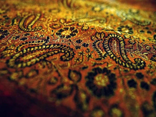 Gold close up detail sari beautiful fabric background, Indian ornament floral pattern with cucumbers on a natural silk cloth. Background for oriental design styles