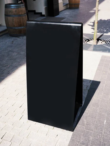 Black modern urban blank metal information board in a front of a store, mock-up per hotel, ristorante in una strada della città. Moderno, elegante . — Foto Stock