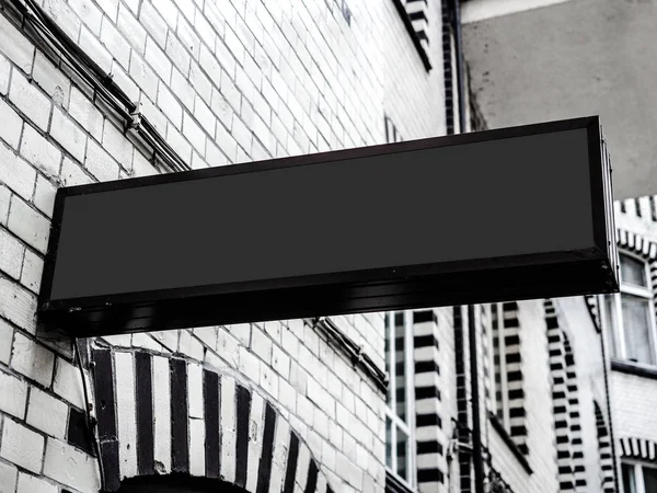 Segnaletica orizzontale moderna nera vuota con cornice nera sul fronte muro della città con mattoni bianchi — Foto Stock
