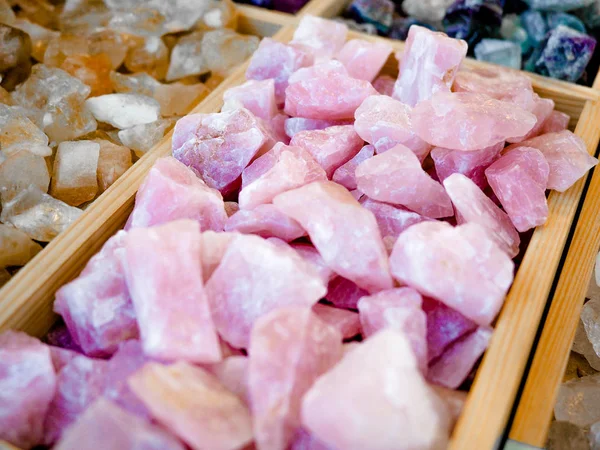 Коллекция розовых необработанных шпинельных драгоценных камней в деревянной коробке, продается на уличном рынке . — стоковое фото