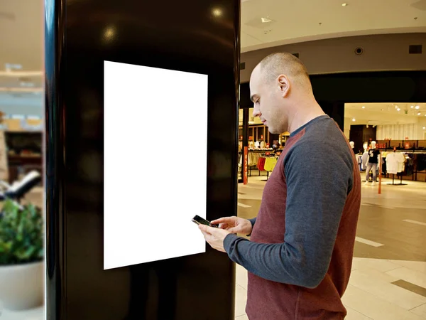 Dijital medya boş siyah ve beyaz ekran modern panel ile bir adam, bir alışveriş merkezinde reklam tasarımı için tabela, Galeri. Mockup, mock-up, bulanık arka plan ile mock up, dijital Kiosk.