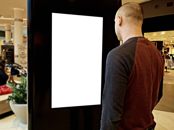 Un hombre con los medios digitales en blanco y negro pantalla panel moderno, letrero para el diseño de anuncios en un centro comercial, galería. Burla, maqueta, maqueta con fondo borroso, quiosco digital . — Foto de Stock